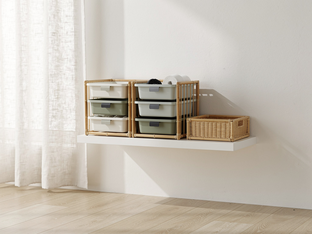 A small set of trays and cubbies arranged as one modular unit on a white shelf, with an extra piece being added beside i